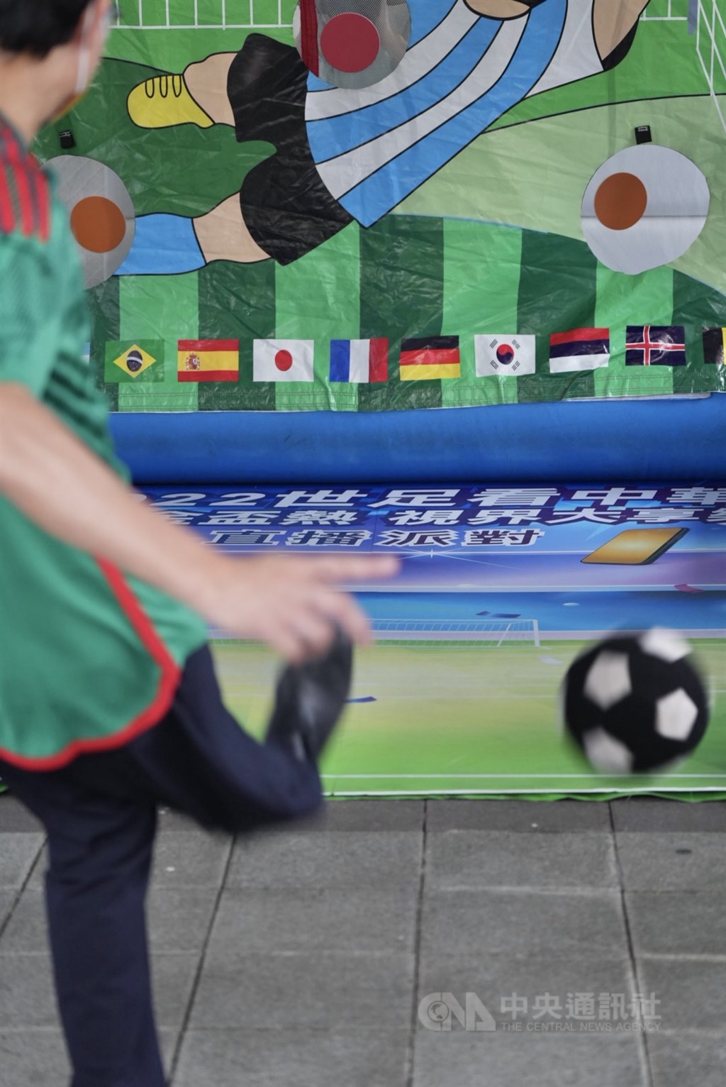 A soccer fan takes a shot at a goal shooting target. CNA photo Nov. 22, 2022