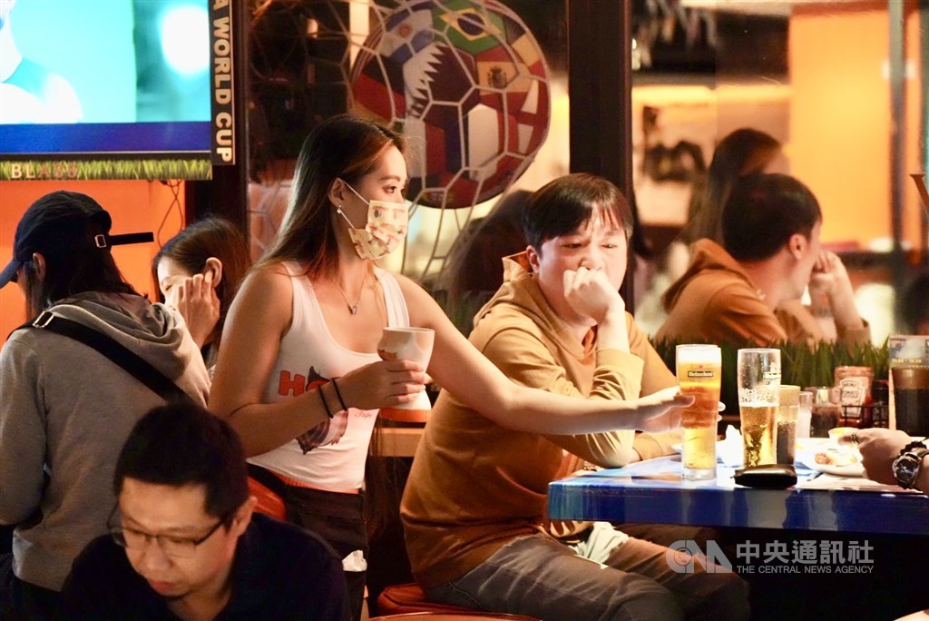 A waitress serves drinks on tap to customers watching the FIFA World Cup at Hooters