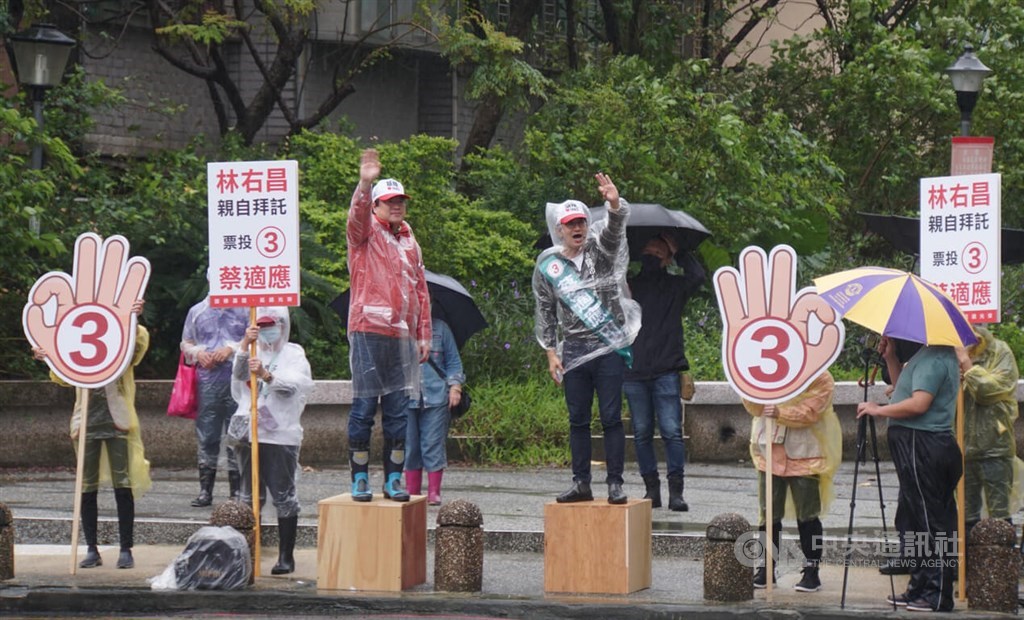 Keelung Mayor Lin Yu-chang (林右昌, center left) and Keelung mayoral candidate Tsai Shih-ying (蔡適應, center right), both are members of the ruling Democratic Progressive Party (DPP), stand on boxes at the side of the road in the port city as they stump for the votes of commuters during the morning rush hour. CNA photo Nov. 23, 2022