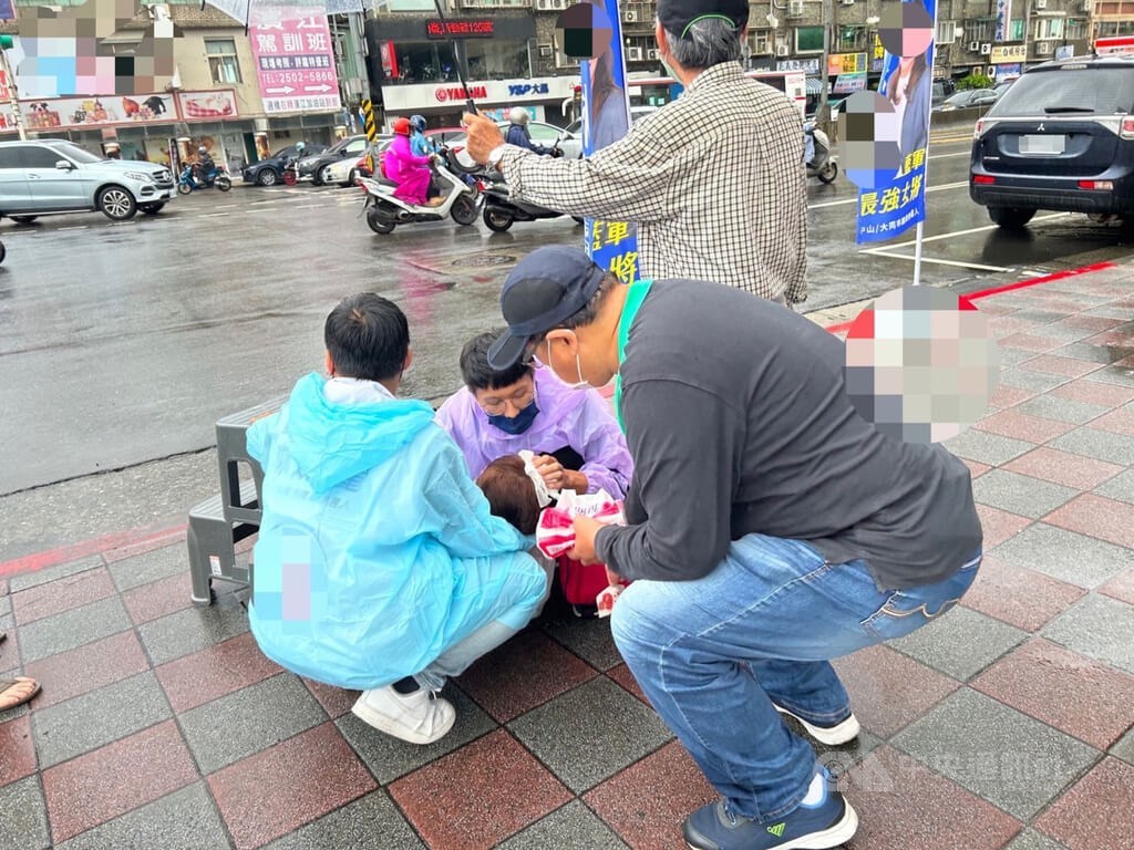 New Party Taipei City Council candidate Lin Chieh-li lies on the ground when people around her tended to her injury in in Zhongshan District on Wednesday. Photo courtesy of a private contributor