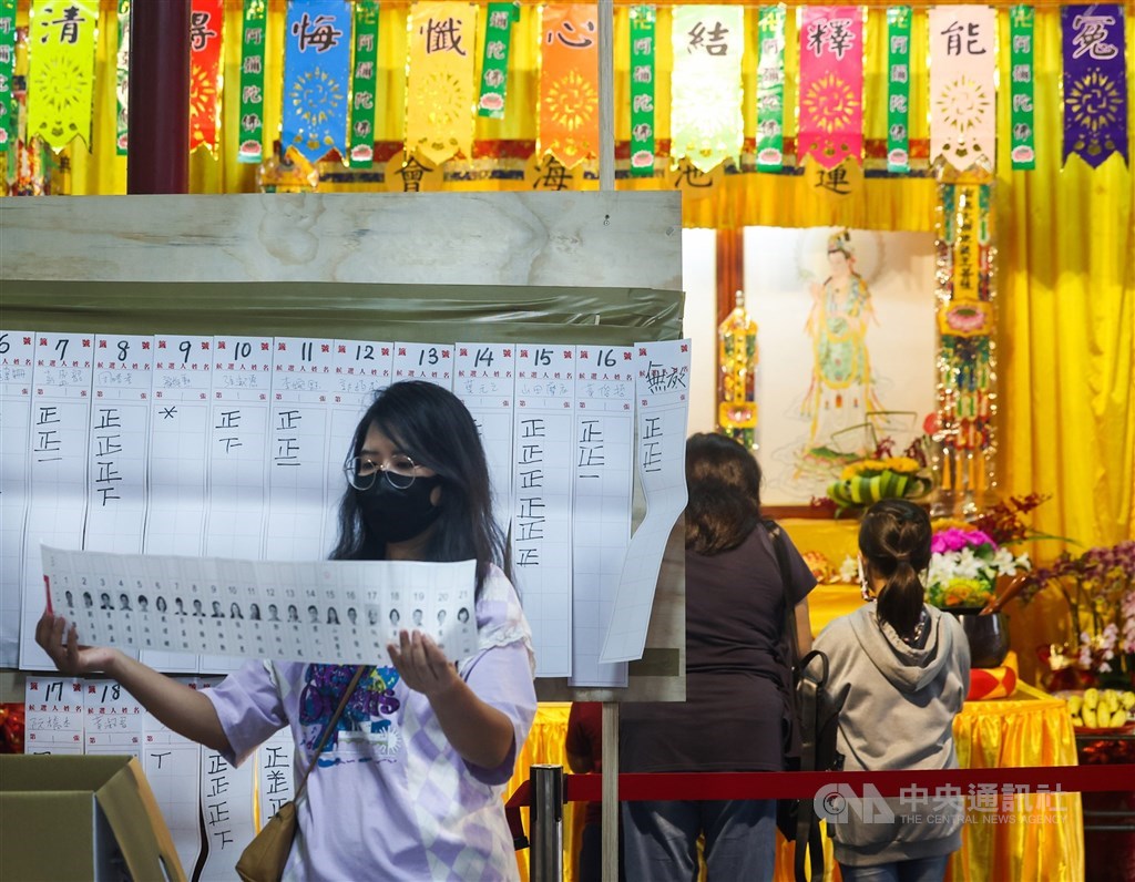 A polling station worker displays a ballot to the public when counting the vote. CNA photo Nov. 26, 2022