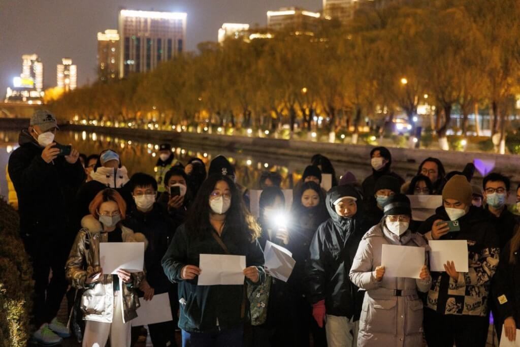 People hold white sheets of paper in protest over COVID-19 restrictions, after a vigil for the victims of a fire in Urumqi, as outbreaks of COVID-19 continue, in Beijing on Nov. 27. Photo: Reuters