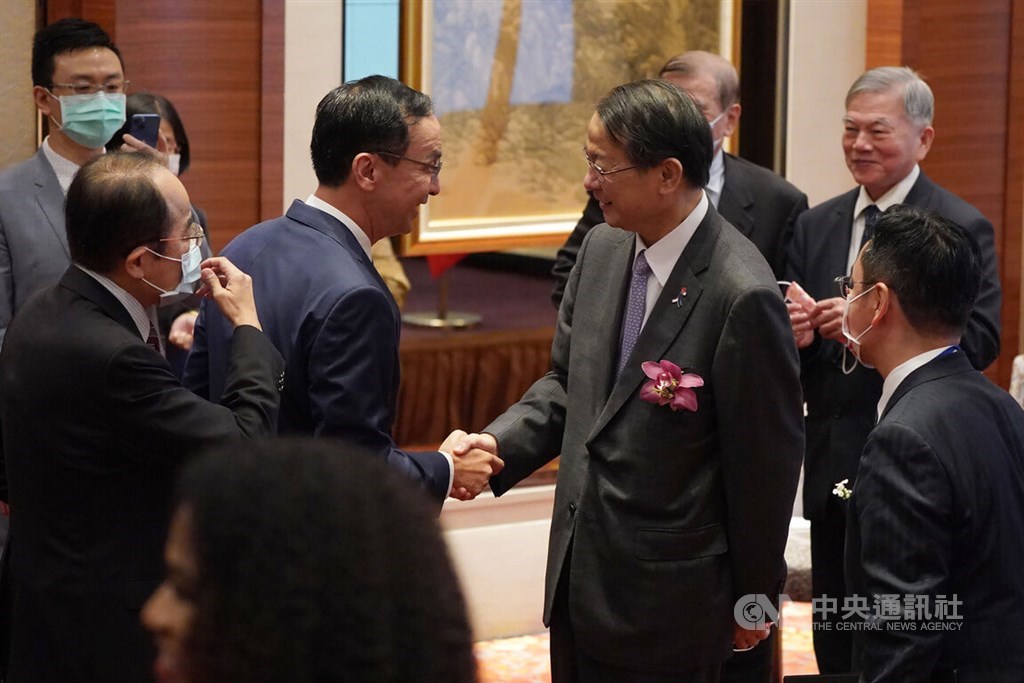 Opposition Kuomintang Chairman Eric Chu (center left) shakes hands with Hiroyasu Izumi, chief representative of the Japan-Taiwan Exchange Association Taipei Office, when he attended Thursday