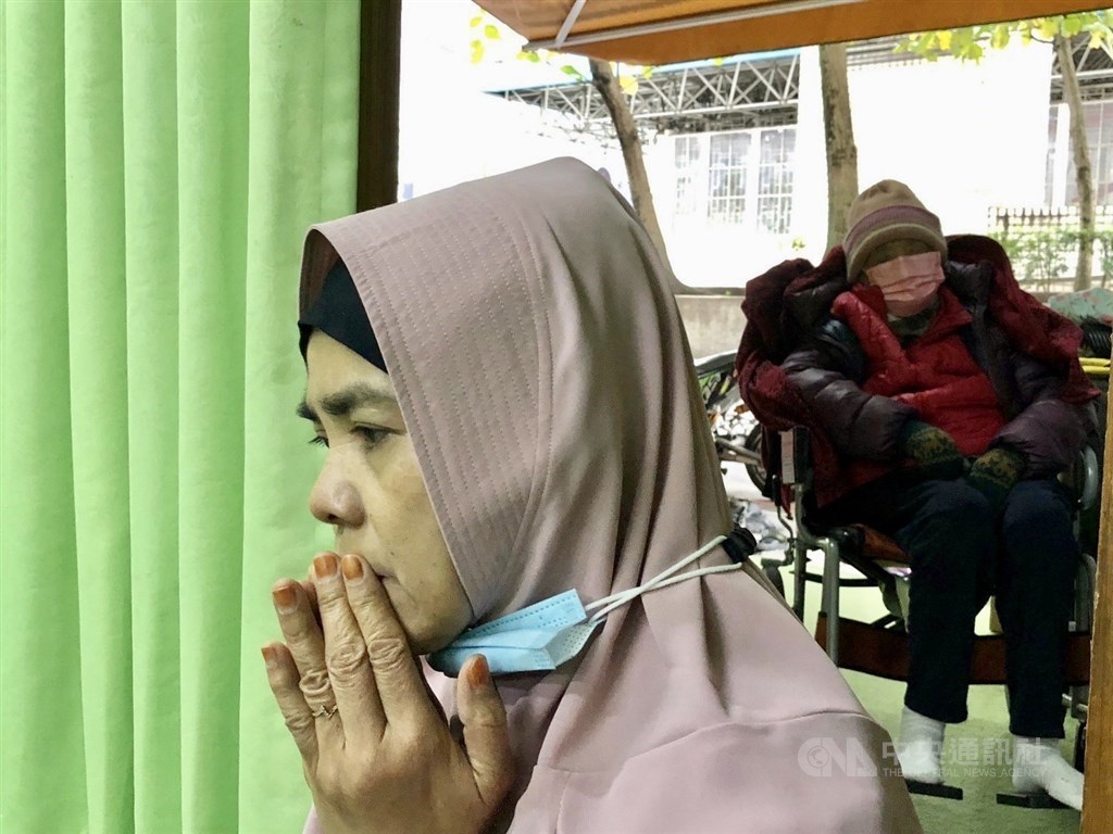 Indonesian migrant worker Binti brings the elderly citizen she takes care of with her when she participates in a worship event at NU’s religious center in Taipei on Dec. 11.