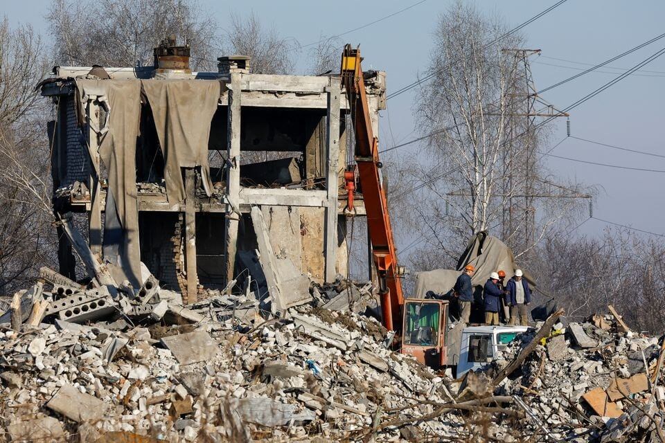 Workers remove debris of a destroyed building purported to be a vocational college used as temporary accommodation for Russian soldiers, 63 of whom were killed in a Ukrainian missile strike as stated the previous day by Russia