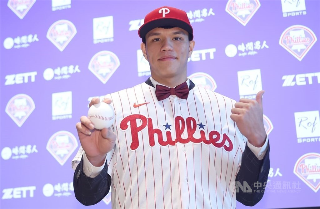 Pitcher Pan Wen-hui holds a baseball in the Philadelphia Phillies jersey at the press conference announcing his signing with the organization Monday in Taipei. CNA photo Jan. 16, 2023