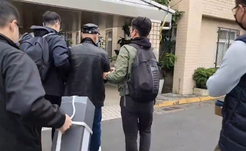 The American passenger, whose checked luggage was found to have bullets in it, is taken into police custody in Taoyuan Thursday in this police photo.