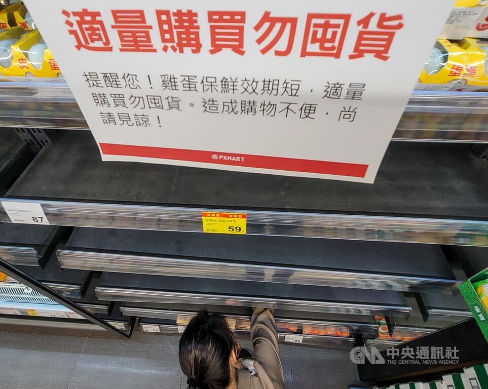 A shopper reaches for a carton of eggs on a bare supermarket shelf in Taipei. CNA photo Feb. 13, 2023