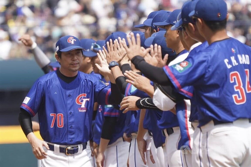 Team Taiwan manager Lin Yueh-ping (left) hi-fives with players before the Sunday