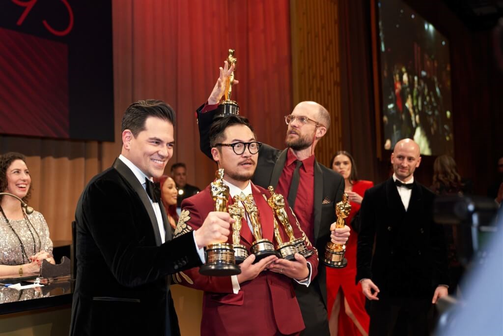 Daniel Kwan (front, center), one of the directors and co-producer of the Oscar-winning absurdist comedy-drama "Everything Everywhere All at Once," holds multiple Oscar trophies with his co-producer Jonathan Wang (front, left) alongside the film