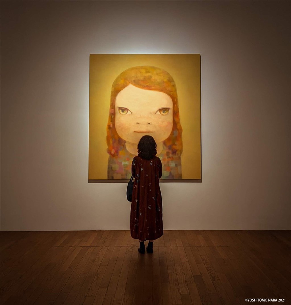 A woman stands in front of Japanese artist Yoshitomo Nara