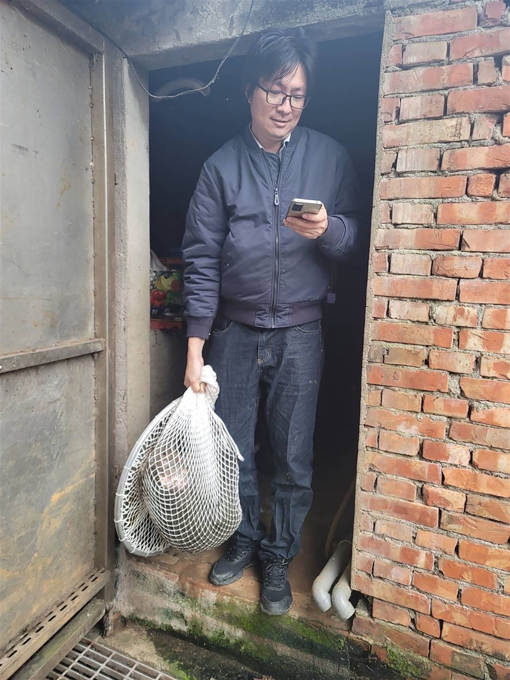 A man carries the caught baboon out of a residence in Taoyuan on Monday. Photo courtesy of a private contributor