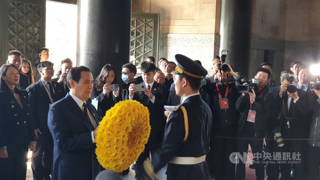 Former President Ma Ying-jeou holds a wreath when paying his respects to the Republic of China