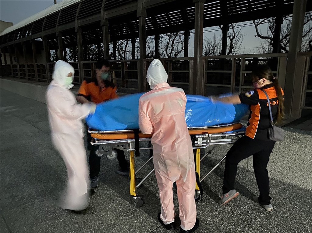 Local government workers move a body found in Tainan
