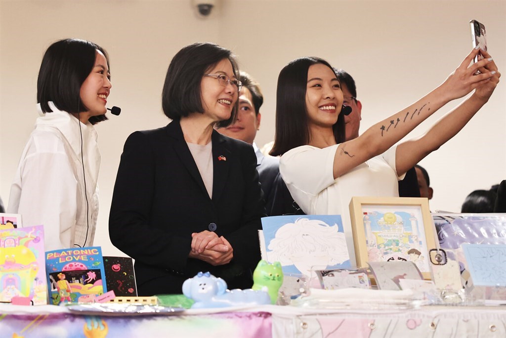 President Tsai Ing-wen (second left) poses for a selfie with a young illustrator she met in New York on Thursday. CNA photo March 31, 2023