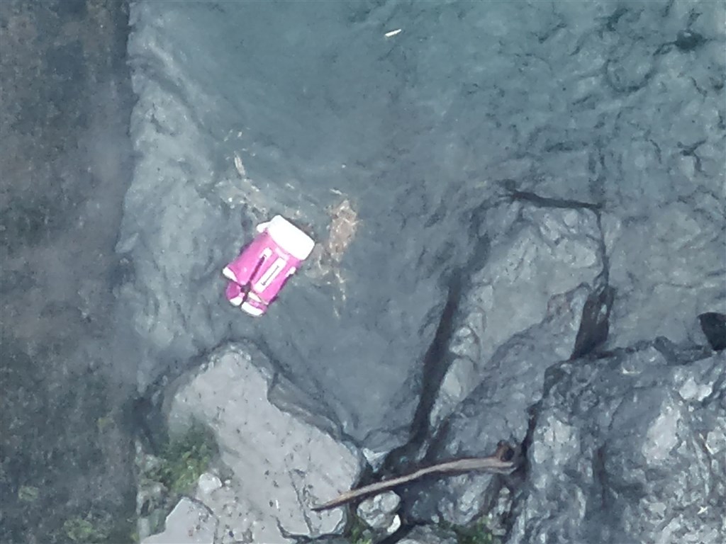 A bag belonging to a male victim of a flash flood is seen floating in the water near Flying Dragon Waterfall in Pingtung
