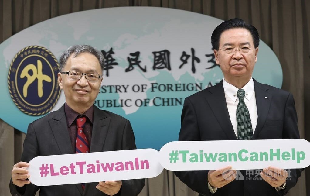 Health Minister Hsueh Jui-yuan (left) and Foreign Minister Joseph Wu hold slogans for Taiwan