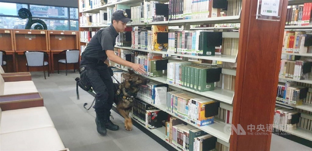 A policeman and a sniffer dog search for bombs allegedly placed in National Taiwan Library on May 16, 2023 in this illustration photo.