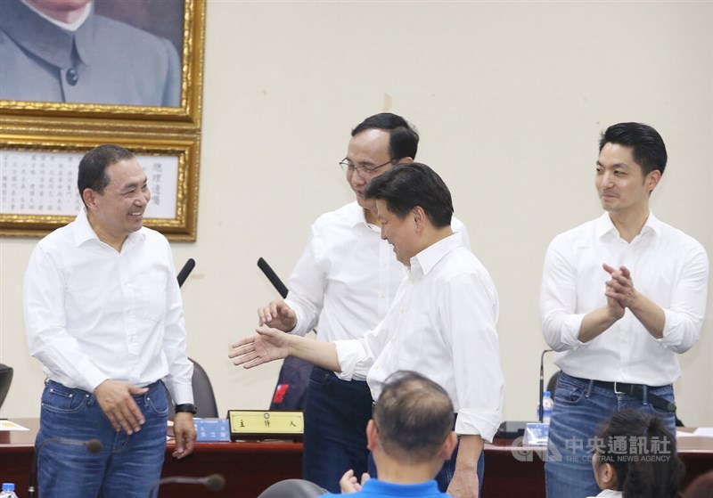 New Taipei Mayor Hou Yu-ih (left) prepares to shake hands with Legislator Fu Kun-chi (center, front) at the KMT Central Standing Committee
