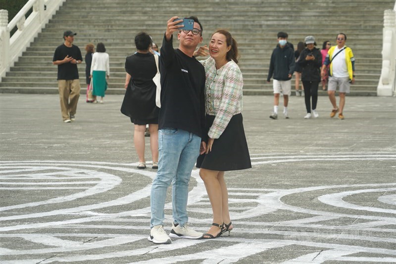 Visitors to National Chiang Kai-shek Memorial Park in Taipei take a selfie with a French artist Jordane Saget