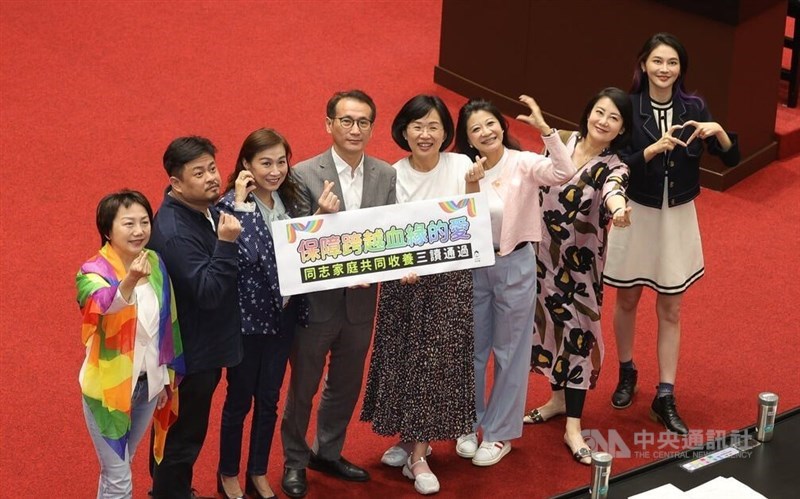 Legislators hold a sign in support of legal amendments allowing same-sex married couples to jointly adopt children, which were passed by the Legislative Yuan on Tuesday. CNA photo May 16, 2023