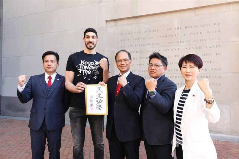 You Si-kun (center) and Enes Kanter Freedom (second left) hold a plaque bearing the words "democracy will prevail" written by You outside the United States Holocaust Memorial Museum in Washington D.C. on Wednesday. CNA photo May 18, 2023