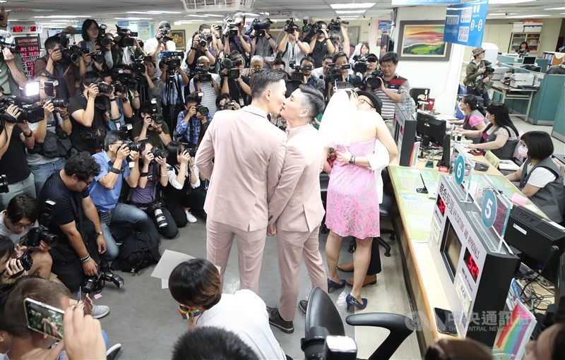 Two couples kiss at the Xinyi Distinct Household Registration Office in Taipei on May 24, 2019, the first day of the implementation of the same-sex law. In Taiwan, a marriage is only valid if it is registered. CNA file photo