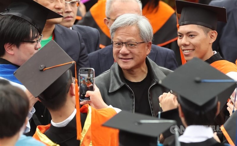 Jensen Huang takes a picture with a National Taiwan University graduate at the school