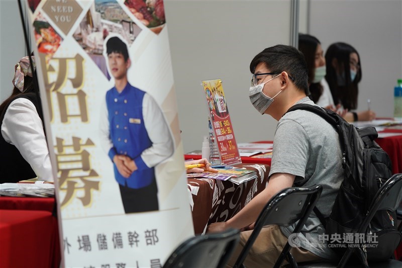 A person sits at the desk and talks to a worker at an employment expo in Taipei in this photo taken on July 11, 2020. CNA file photo
