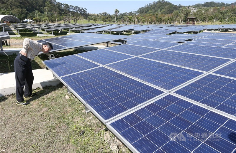 Former Taipei Mayor Ko Wen-je takes a closer look at solar panels installed at a park, the site of which was Fude Landfill in the city