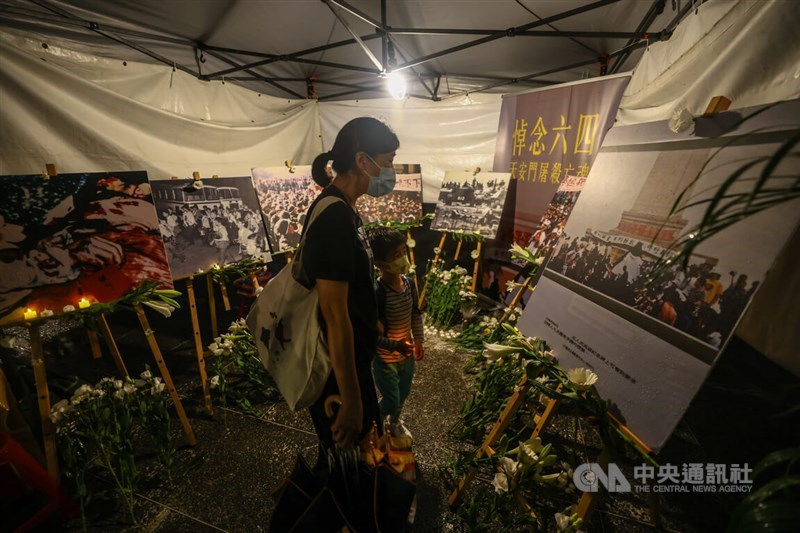 A woman and a boy visit a tent that displays images of the Tiananmen Square crackdown in 1989, at the vigil in Taipei on Sunday. CNA photo June 4, 2023