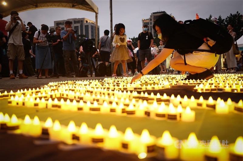 Attendees of the annual vigil to remember a violent crackdown on pro-democracy protesters by Chinese authorities in Beijing 34 years ago on June 4 place candles in front of the Chiang Kai-shek Memorial Hall Sunday. CNA photo June 4, 2023