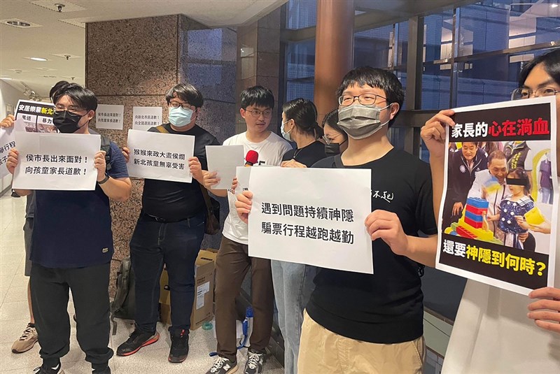 A group of students on Thursday hold placards in a protest against New Taipei City Mayor Hou Yu-ih at National Chengchi University over the city