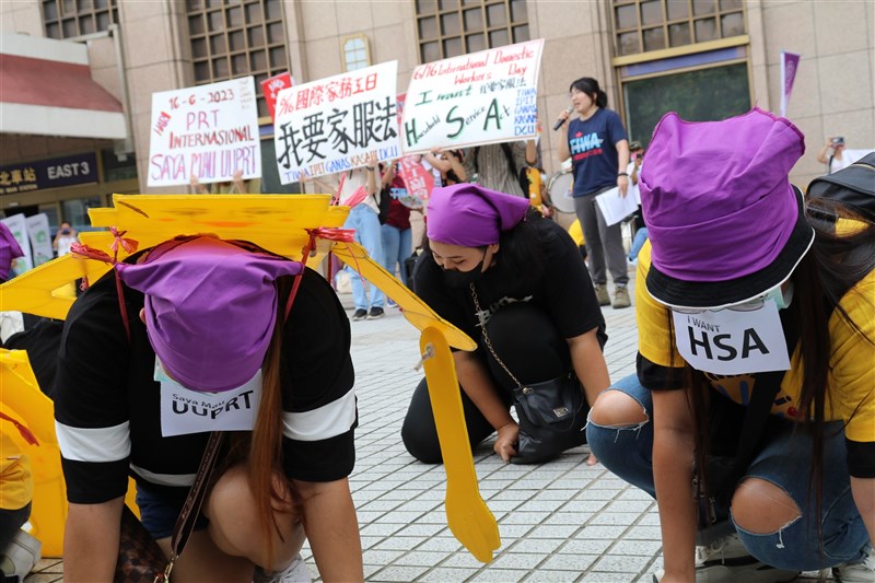 Filipino and Indonesian migrant caretakers gather outside Taipei Main Station dressed up as metaphorical "robots" in peaceful protest of their long work hours and low salary. CNA photo June 18, 2023