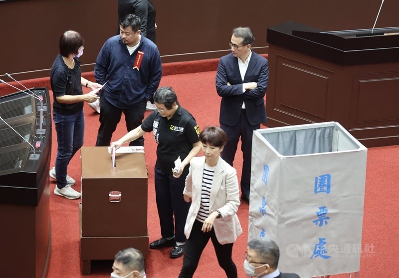 New Power Party Legislator Chen Jiau-hua (center, in black polo shirt) casts her ballot at the Legislature in Taipei Wednesday. CNA photo June 21, 2023