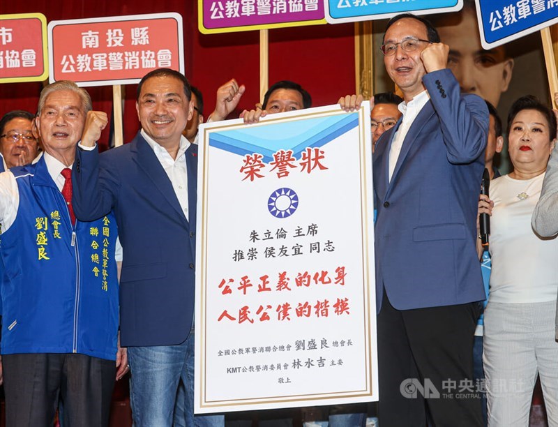 KMT Chairman Eric Chu (right) presents an honorary certificate to New Taipei Mayor Hou Yu-ih (second left) when attending a meeting of a federation set up for public sector workers, including policemen, firefighters and military personnel in Taipei Thursday. CNA photo July 13, 2023