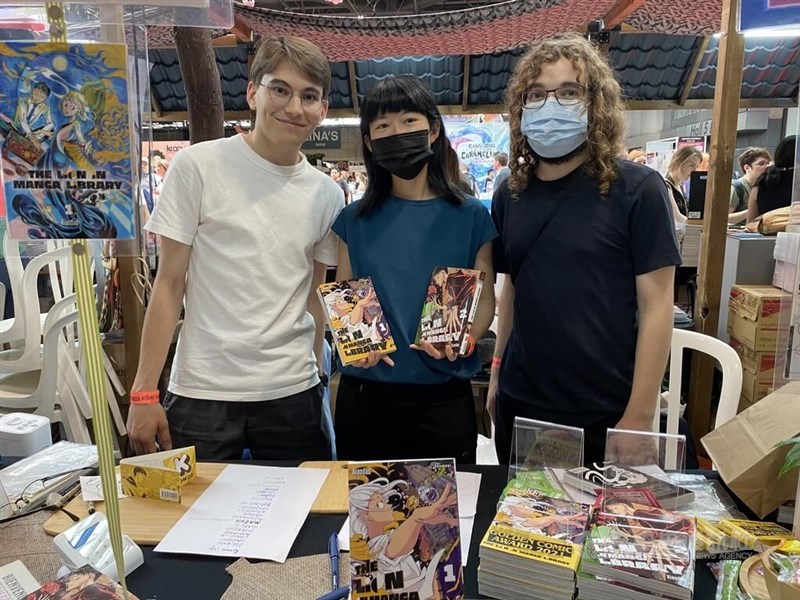 Taiwanese cartoonist Xiaodao (center) displays two French translations of "Crouching Lion in a Bookstore" she authors at the Japan Expo in Paris Sunday. CNA photo July 16, 2023