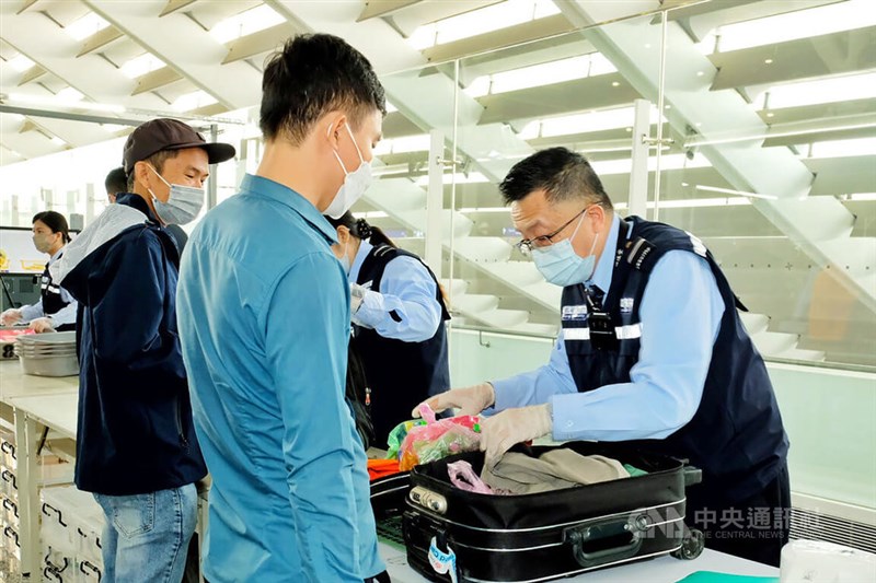 Airport security personnel check the luggage of arriving passengers at Taoyuan International Airport for meat products on Oct. 25, 2022. CNA file photo