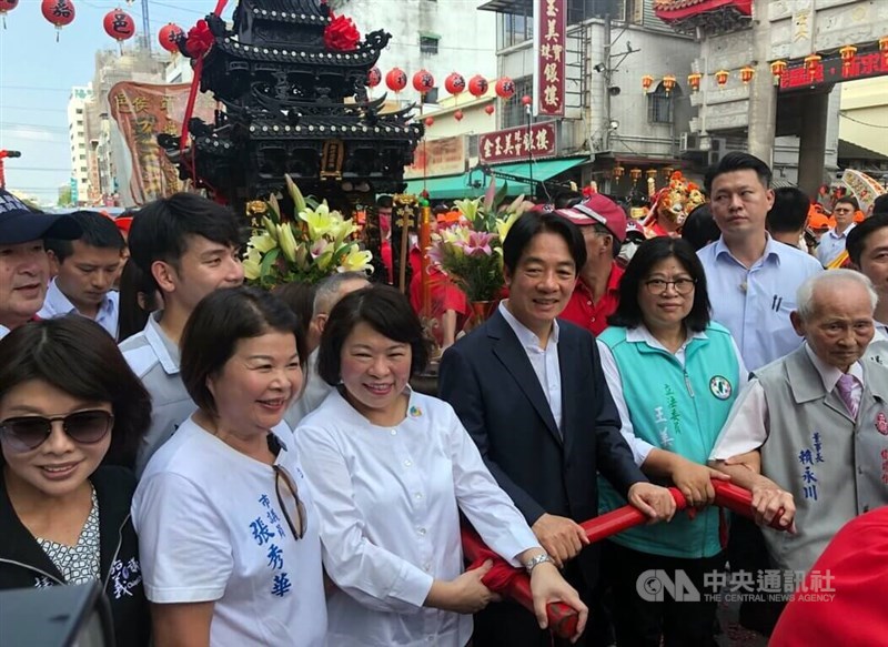 Vice President Lai Ching-te (in suit), Chiayi City Mayor Huang Min-hui (third left) and DPP Legislator Wang Mei-hui (fifth left) carry the palanquin of the city god enshrined in Chiayi City