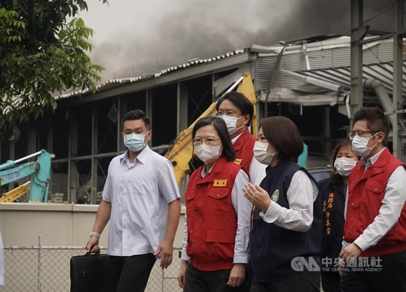President Tsai Ing-wen (second left) listens to a briefing by Pingtung County Magistrate Chou Chun-mi (in black vest) during her visit to the factory fire site Friday. CNA photo Sept. 23, 2023