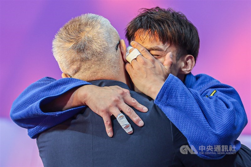 Yang Yung-wei (right) hugs his coach Liu Wen-teng in tears after winning Team Taiwan