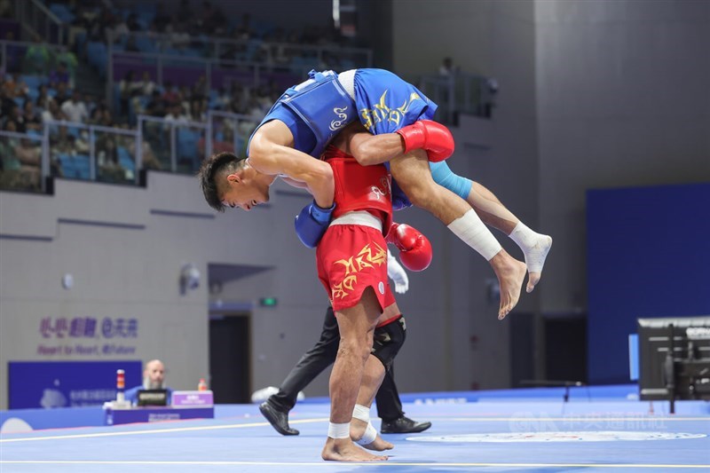 Three-time Asian Games champion Mohsen Mohammadseifi (in red) of Iran carries Taiwanese athlete Zhang Huan-yi off the combat area following their semifinal match at the Asian Games in Hangzhou, China, on Wednesday. CNA photo Sept. 27, 2023