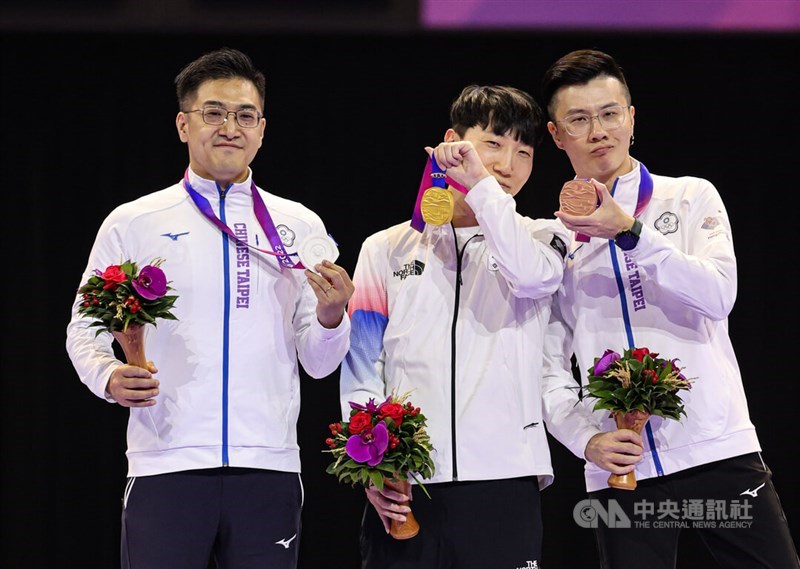 Taiwanese esports players Hsiang Yu-lin (left) and Lin Li-wei (right) poses with gold medal winner, Kim Gwan-woo of South Korea at the medal ceremony at the Asian Games in Hangzhou, China, on Thursday. CNA photo Sept. 28, 2023