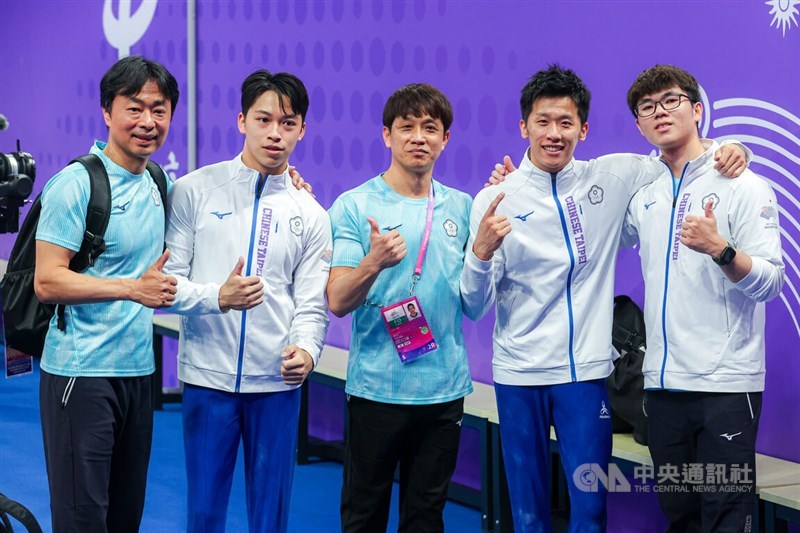 Gymnast Lee Chih-kai (second right) poses with his coach Lin Yu-hsin (center), fellow pummel horse competitor Shiao Yu-jan (second left), who finished fourth in the final, and team officials following his defended his Asian Games title in Hangzhou, China, on Thursday. CNA photo Sept. 28, 2023