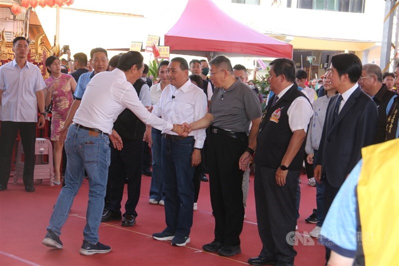 Foxconn Technology Group founder Terry Gou (left, in jeans) shakes hands with Taiwan People
