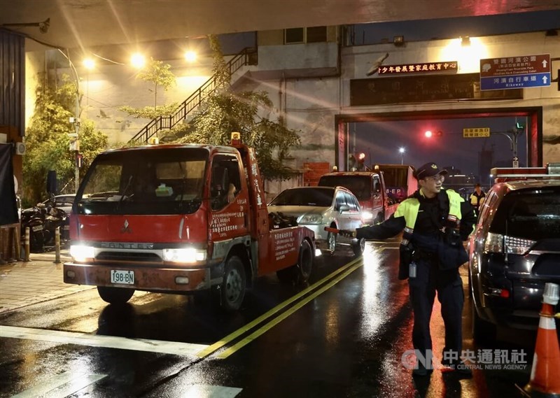 Tow trucks remove idle vehicles parked inside the vicinity of the Tamsui River in preparation of the incoming typhoon Tuesday. CNA photo Oct. 3, 2023