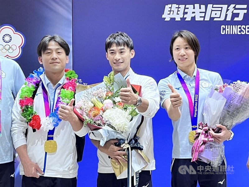 Hangzhou Asian Games gold medalists Yang Yung-wei (center) and Lien Chen-ling (right) pose for the press at Taoyuan International Airport on Sept. 29, 2023. CNA file photo