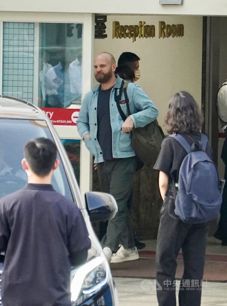 Coldplay drummer Will Champion (in light blue jacket) walks out of a terminal building at Kaohsiung International Airport Friday. CNA photo Nov. 10, 2023