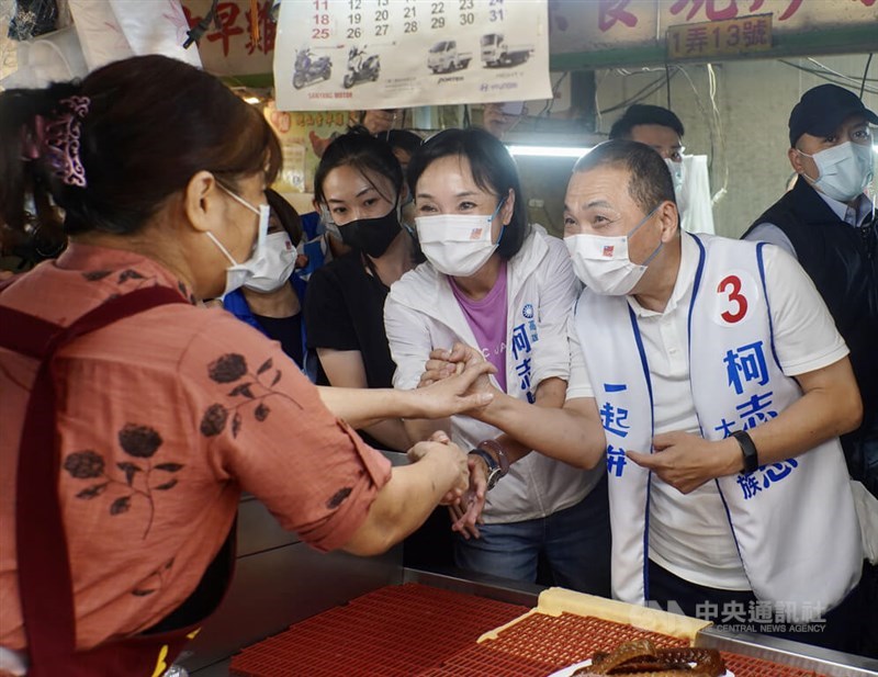New Taipei Mayor Hou Yu-ih (right) and KMT Kaohsiung mayoral candidate (second right) shake hands with a market vendor in Kaohsiung on Nov. 4, 2022, as they campaign for the local government elections on Nov. 26. CNA file photo