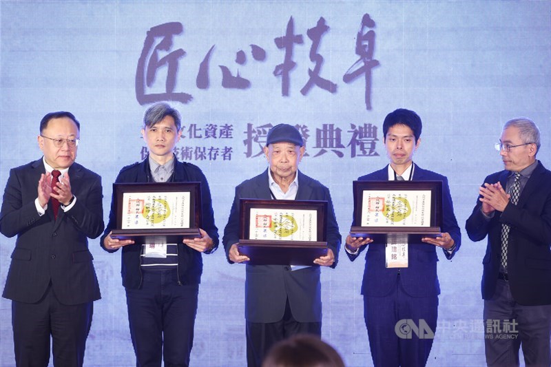 Culture Minister Shi Che (left) applauds the three people that were awarded the title of "national treasure" for their contribution to preserving Taiwan's cultural heritage at a ceremony held by the Ministry of Culture in Taipei on Friday. CNA photo Nov. 24, 2023